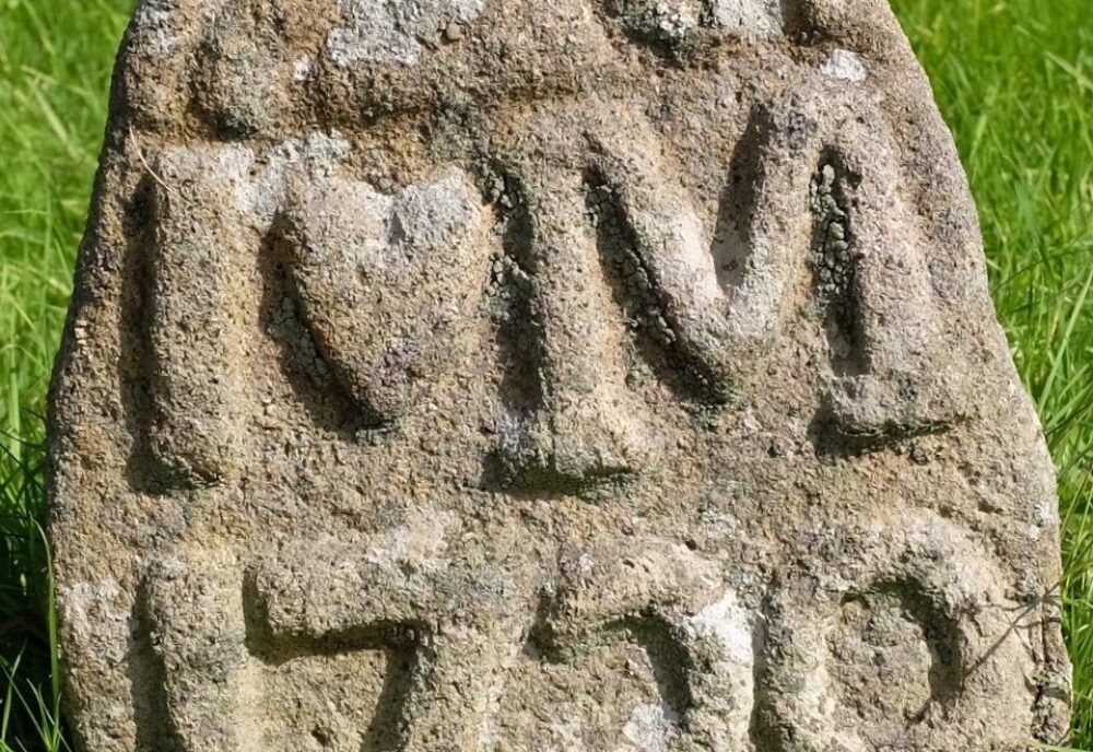 Granite headstone. Inscription IM 1729 in large raised letters. Granite headstone. Inscription IM 1729 in large raised letters.