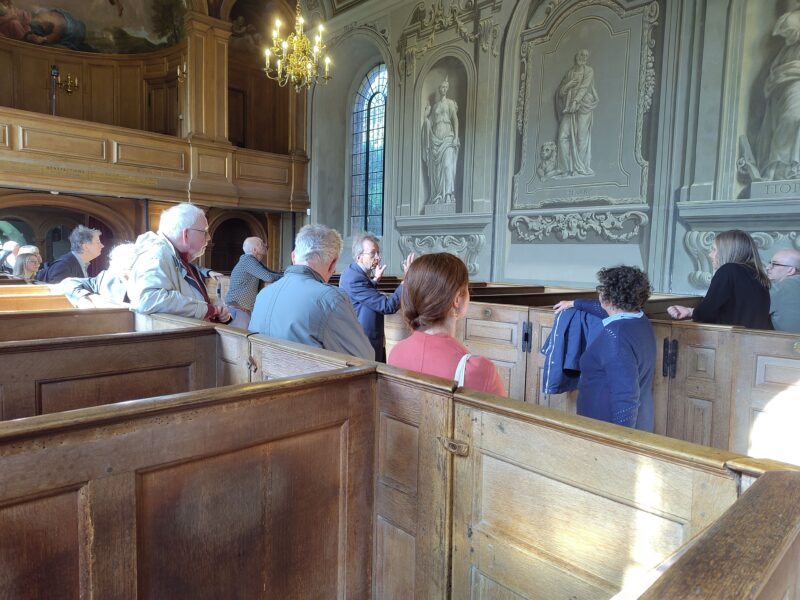 Group on tour of Baroque church with fictive sculpture of Evangelists and Virtues on the walls