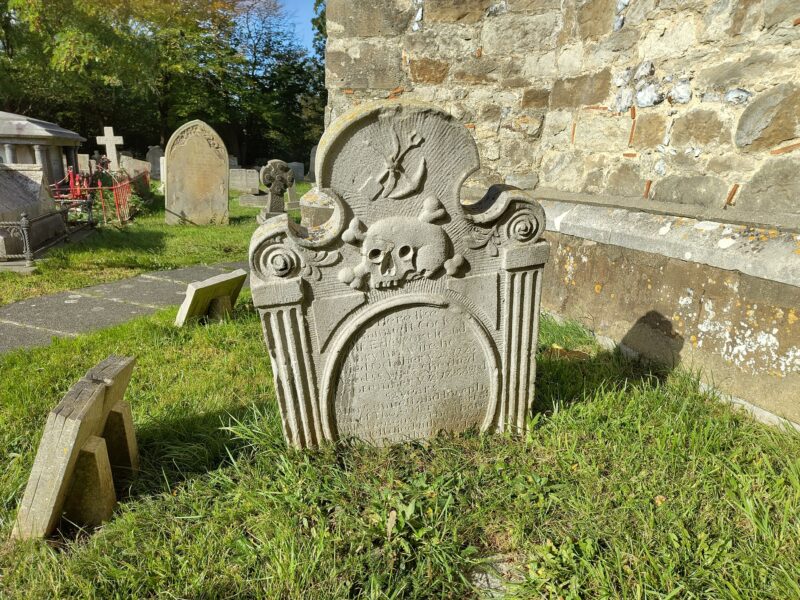 Tombstone with skull, bones and gravedigger's tools