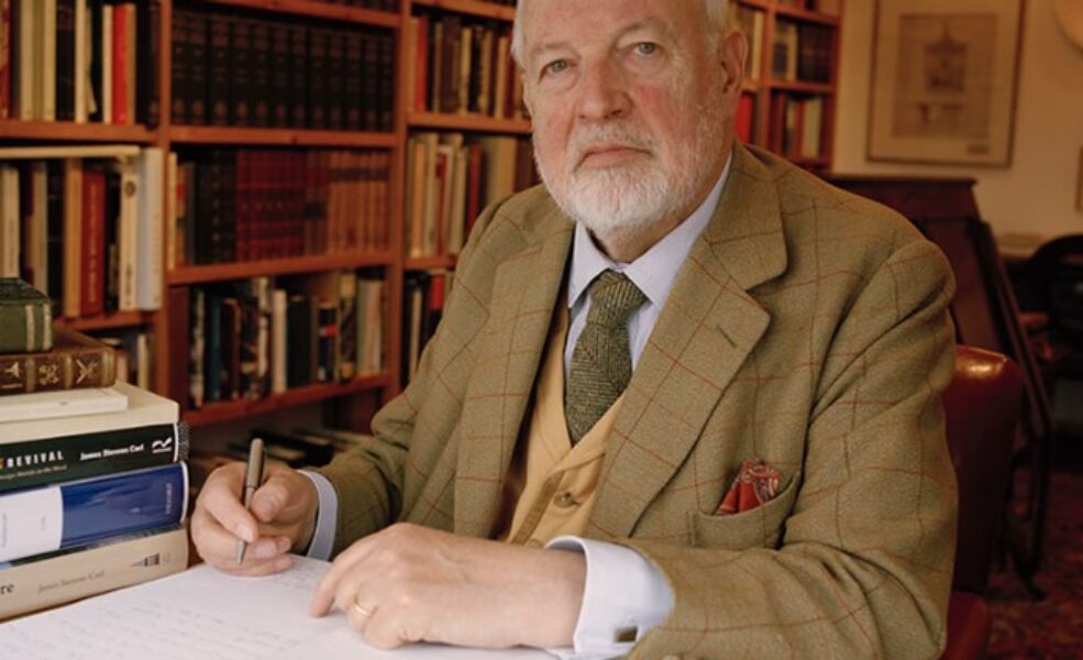 Bearded man in library, papers on desk Bearded man in library, papers on desk