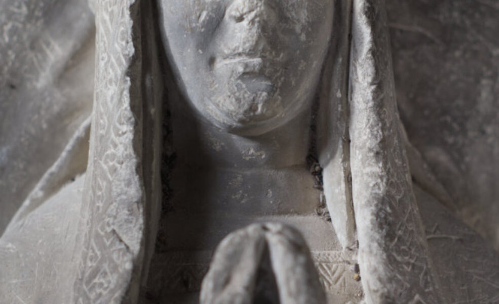 Upper part of effigy of woman, early C16. She wears a n english hood with long lappets.
