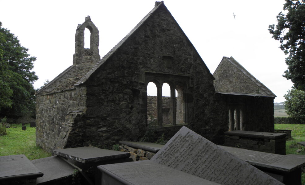 Ruined church with damaged gravestones in foreground
