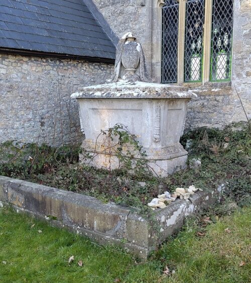 Exterior of church with chest tomb and plinth covering vault