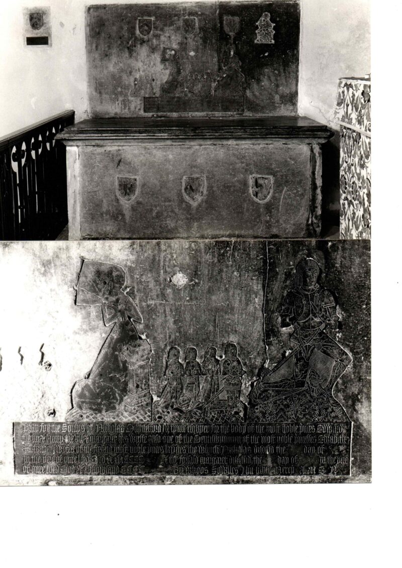 Detail of monumental brass above tomb chest. Brass has kneeling female figure with butterfly head-dress, male figure in armour, children kneeling behind them
