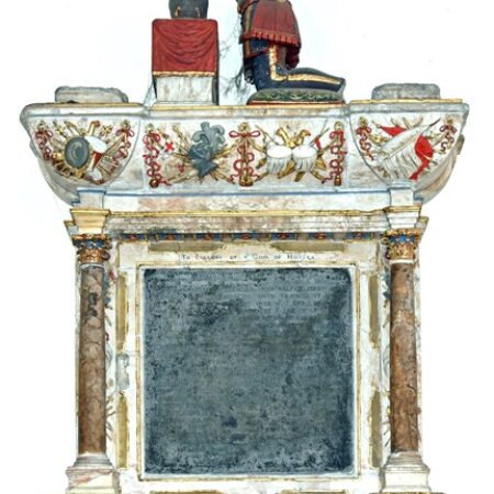 Remains of wall monument with kneeling figure on top, elaborate baroque decoration surrounding inscription plaque